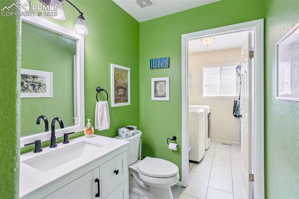 Image 15 of 32: Bathroom with independent washer and dryer, vanity, and a textured wall