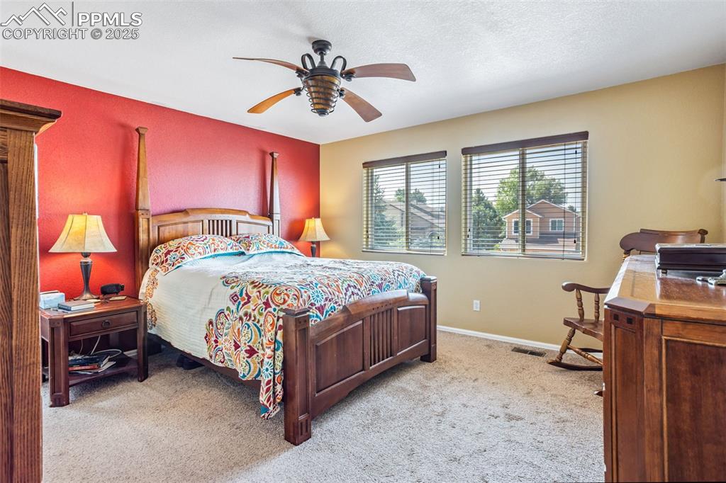 Image 17 of 32: Bedroom with carpet flooring and a ceiling fan