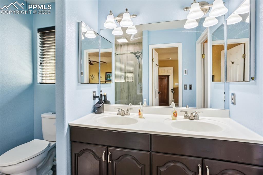 Image 19 of 32: Bathroom featuring double vanity and a shower stall