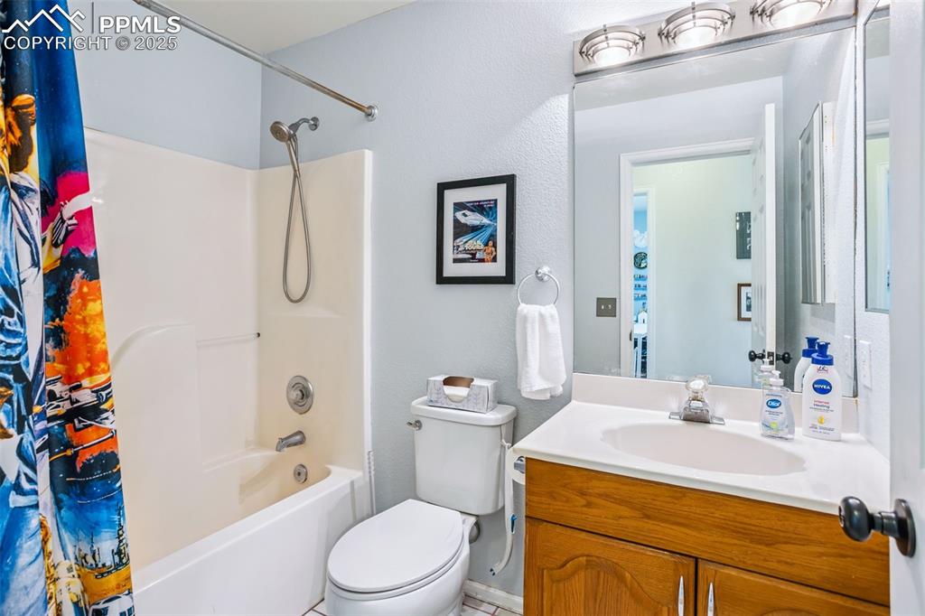 Image 24 of 32: Bathroom featuring shower / bathtub combination with curtain and vanity