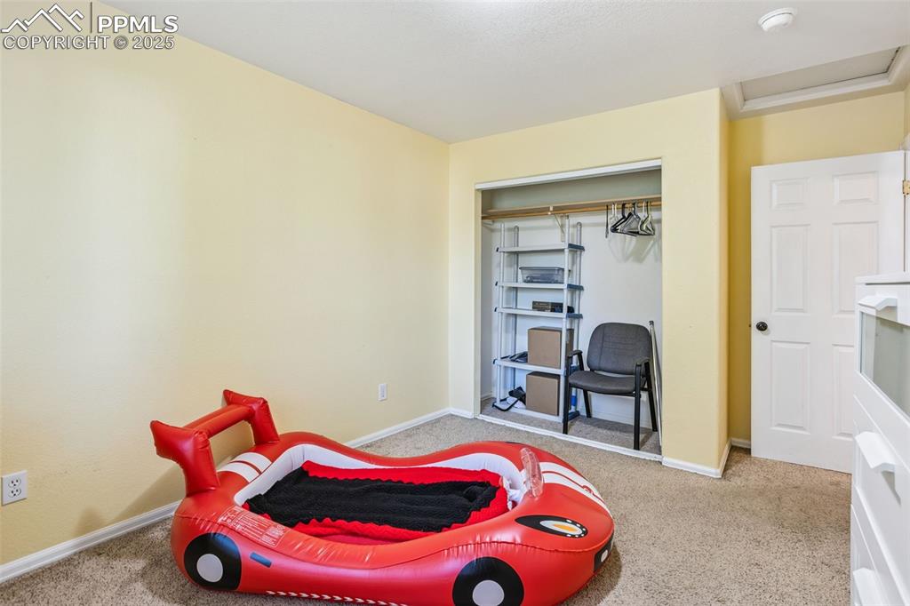 Image 25 of 32: Carpeted bedroom with attic access and a closet