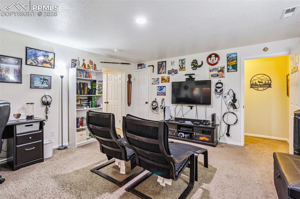 Image 27 of 32: Living room featuring an office area, carpet flooring, and a textured ceili