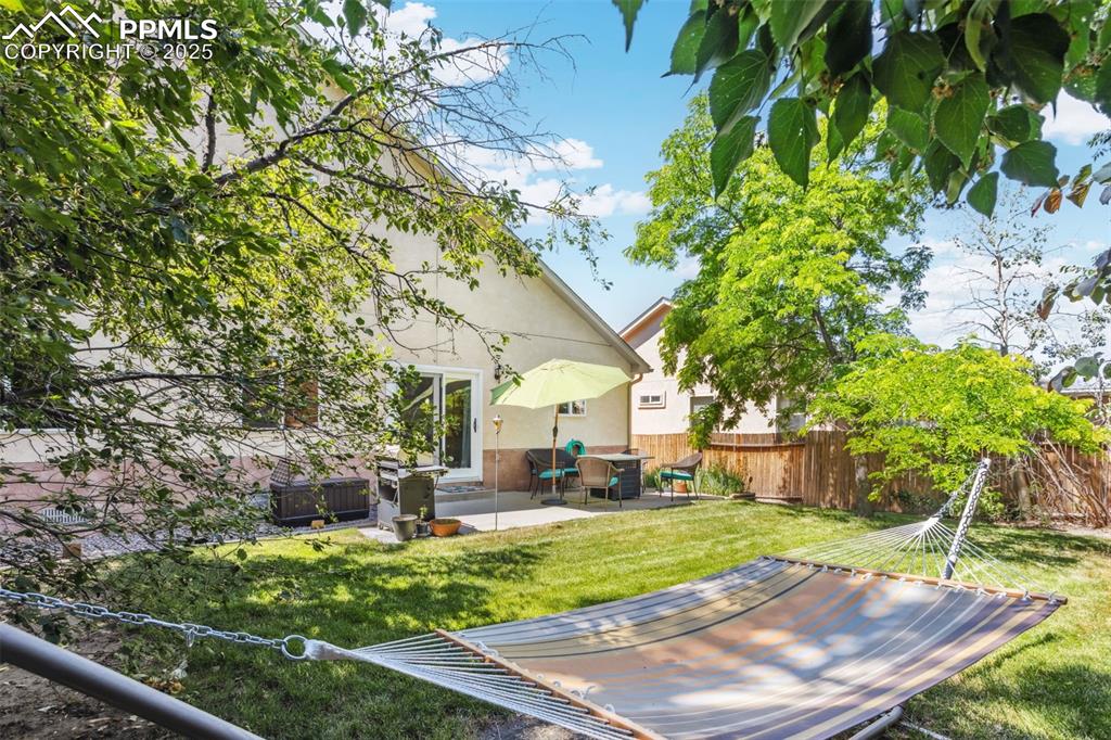 Image 30 of 32: Fenced backyard featuring a patio