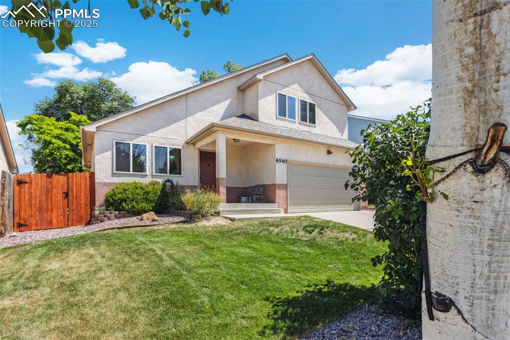 Image 6 of 32: View of front of home featuring stucco siding, concrete driveway, a garage,
