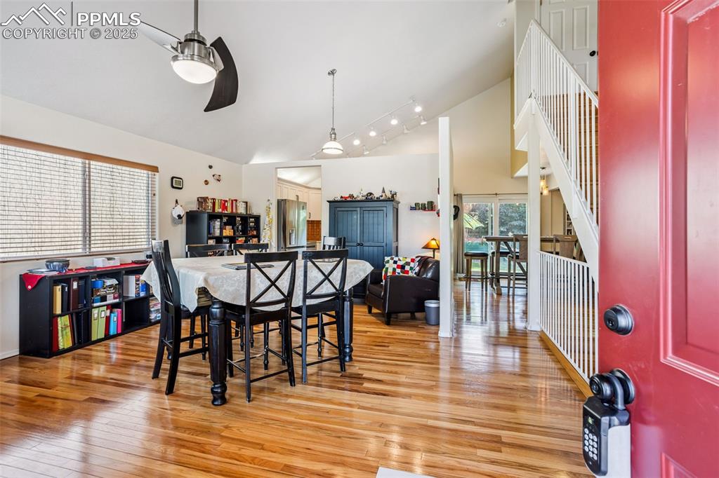 Image 9 of 32: Dining space with a ceiling fan, light wood-style flooring, and high vaulte