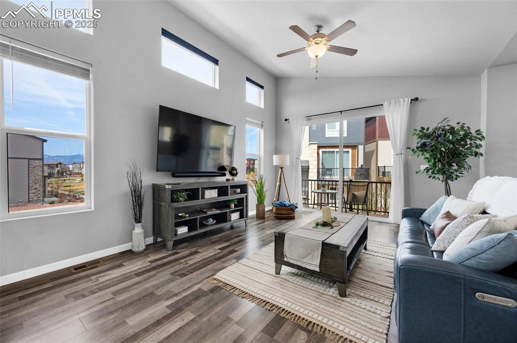 Image 5 of 40: Living room featuring high vaulted ceiling, a ceiling fan, visible vents, w