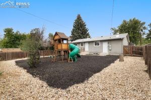 Image 24 of 26: Beautifully re-landscaped back yard with childrens playset