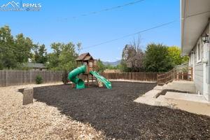 Image 26 of 26: Additional view of back yard with playset