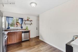 Image 6 of 26: Kitchen walks out to large fenced back yard with new mulch and childrens pl