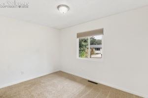 Image 9 of 26: Main Level master bedroom with carpet and window covering