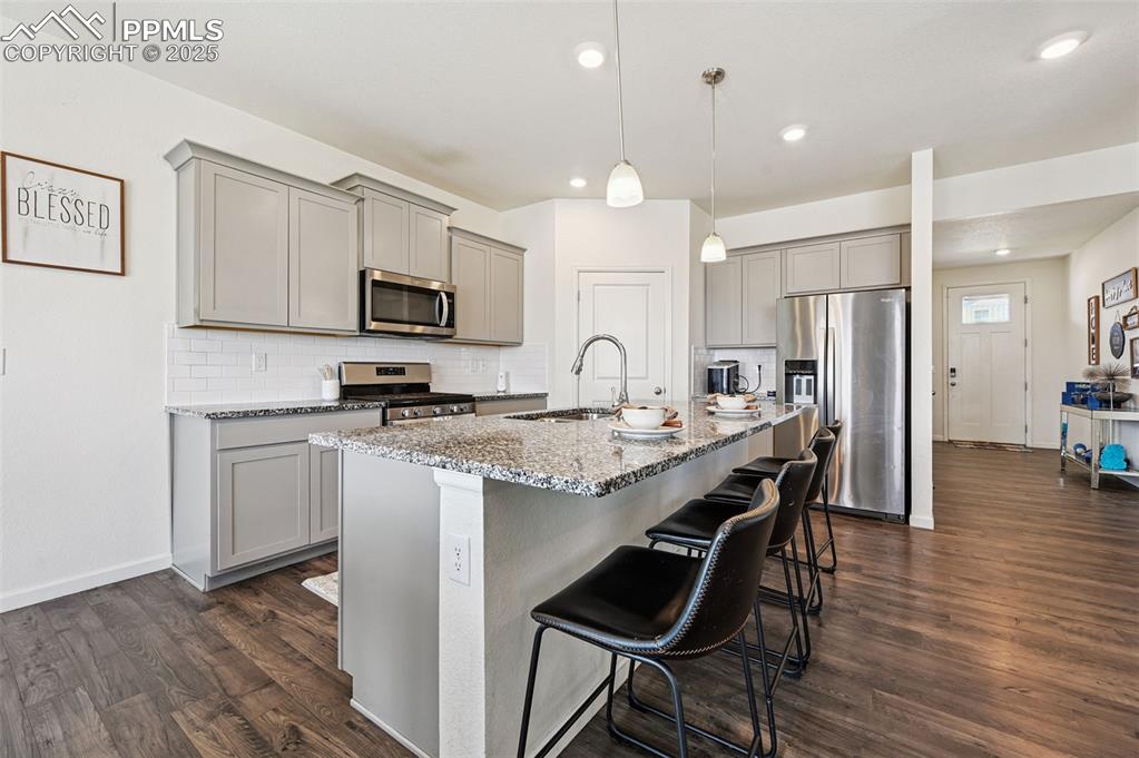 Image 3 of 32: Kitchen with gray cabinets, stainless steel appliances, tasteful backsplash