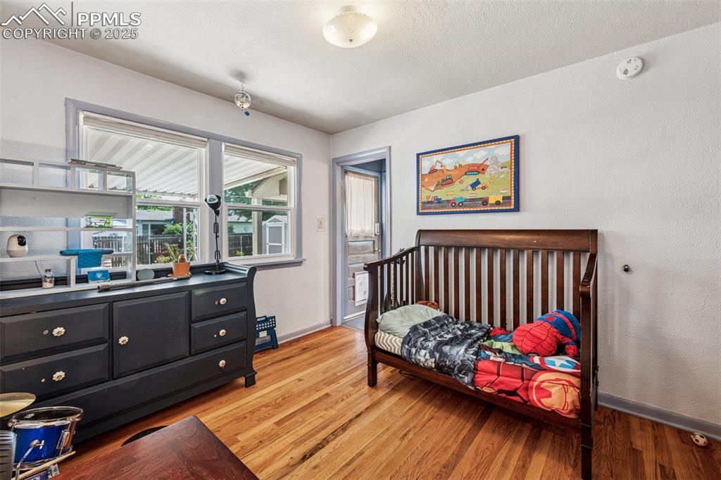 Image 17 of 30: Bedroom with light wood-style floors and a textured ceiling