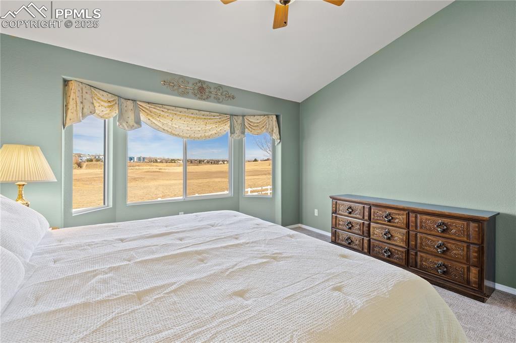 Image 8 of 41: Bedroom with carpet floors, vaulted ceiling, and a ceiling fan