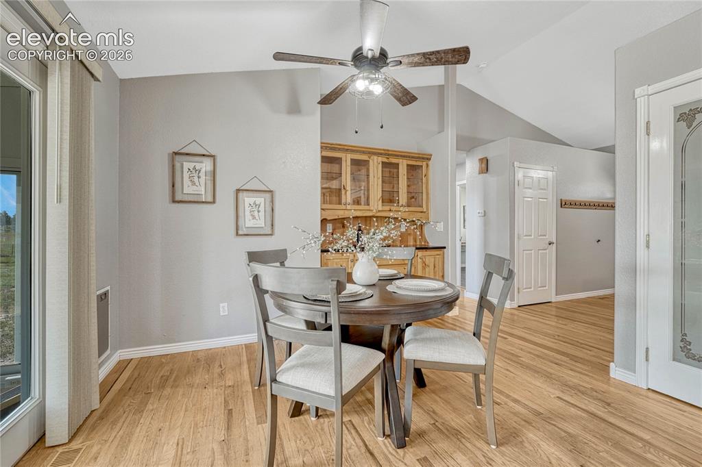 Image 14 of 39: Dining area with oak floors and built-in hutch. 