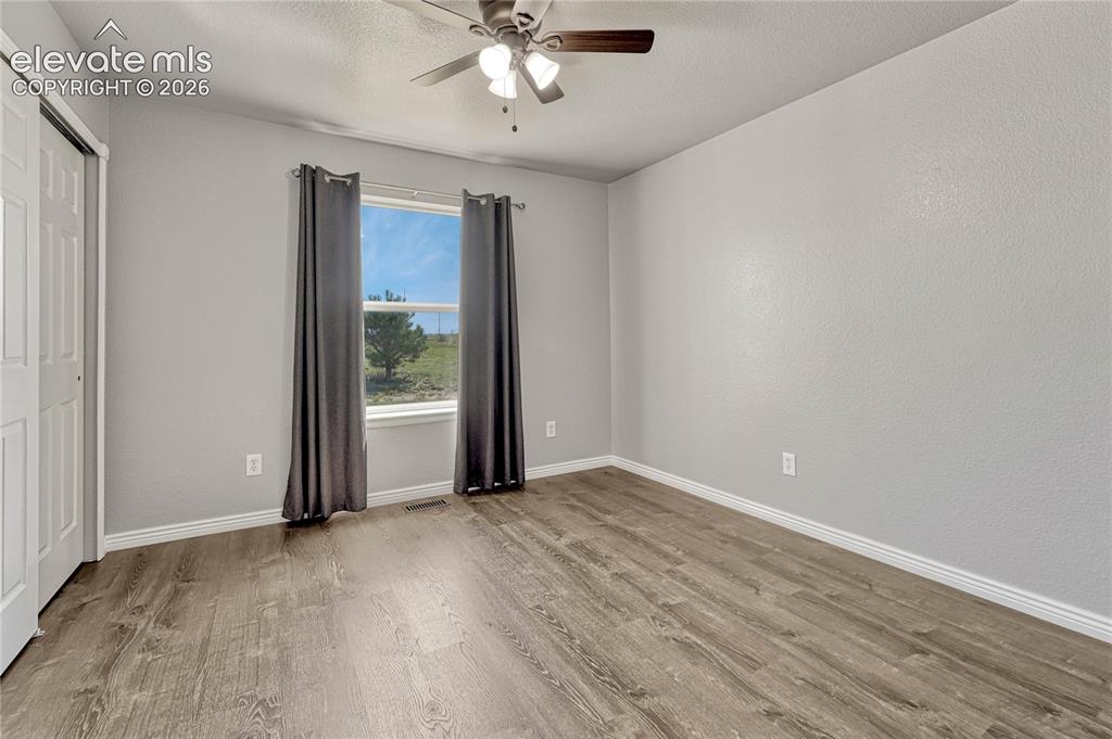 Image 24 of 39: Second of two additional main level bedrooms with luxury vinyl flooring. 