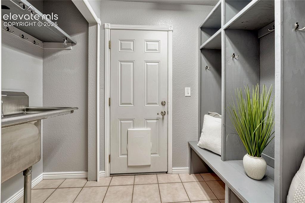 Image 25 of 39: fMud room with garage access, stainless steel utility sink and storage. 