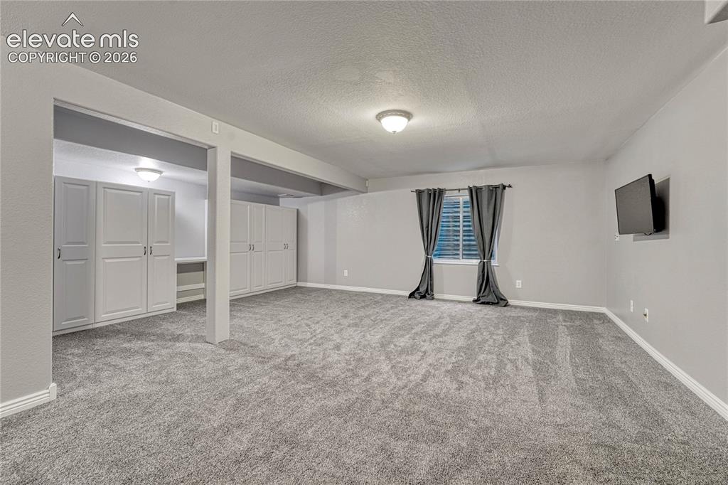 Image 27 of 39: Large family and recreation room has great built-in storage and is pre-plum