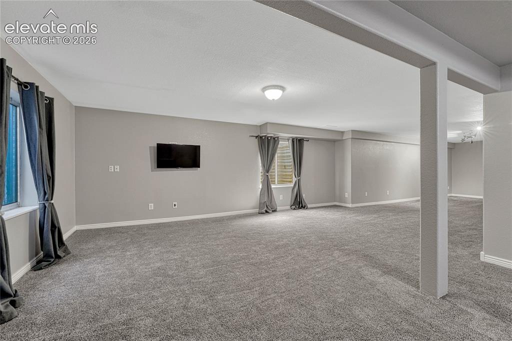 Image 28 of 39: Large carpeted family and recreation room.