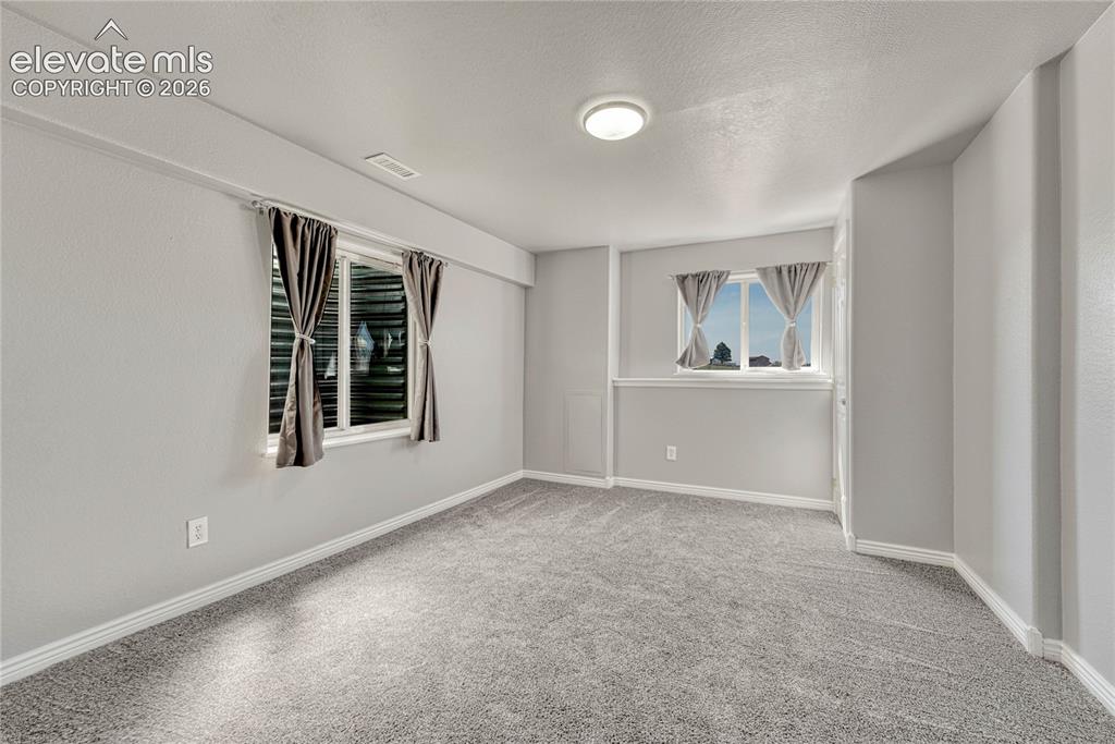 Image 29 of 39: First of two basement bedrooms.