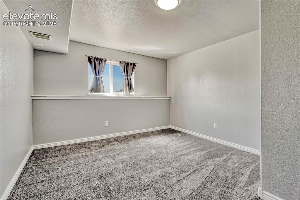 Image 31 of 39: Second of two basement bedrooms.