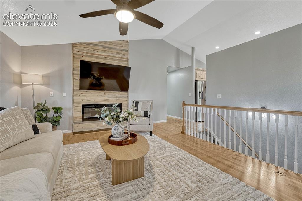 Image 7 of 39: ...and electric fireplace with cozy cabin-style wood surround.