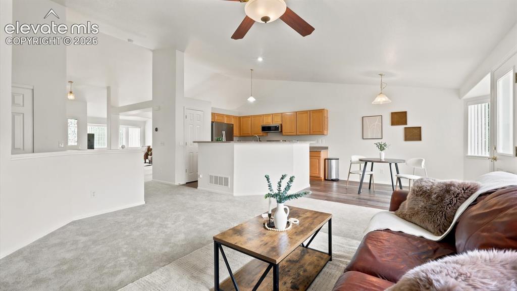 Image 23 of 46: The Family Room has neutral carpet, a lighted ceiling fan, and walk out to 