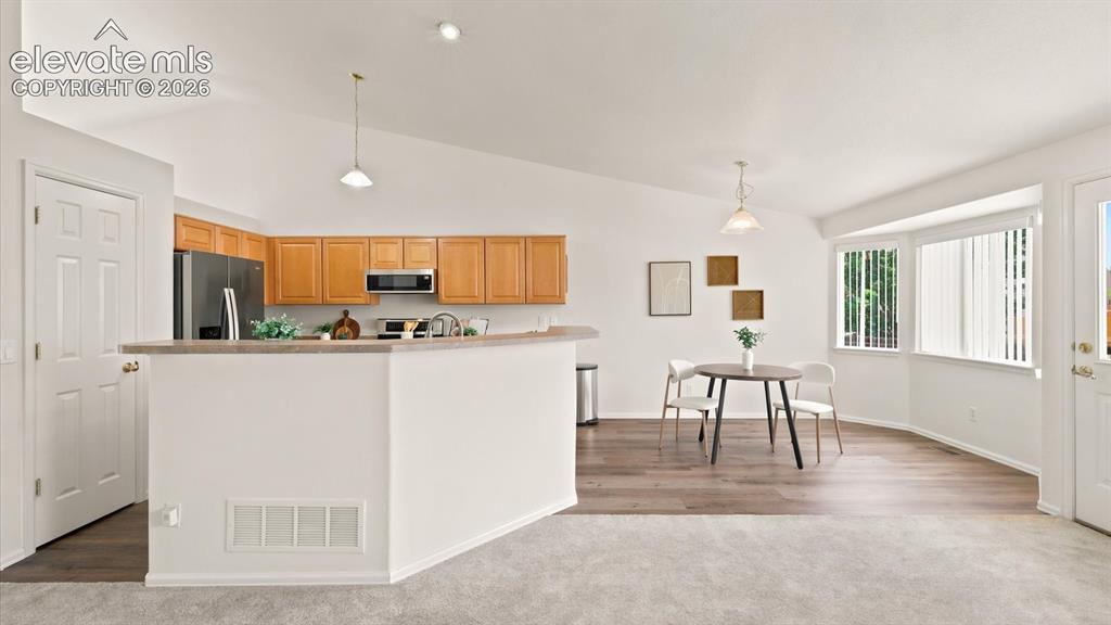Image 25 of 46: View of the Kitchen and Breakfast Nook from the Family Room.