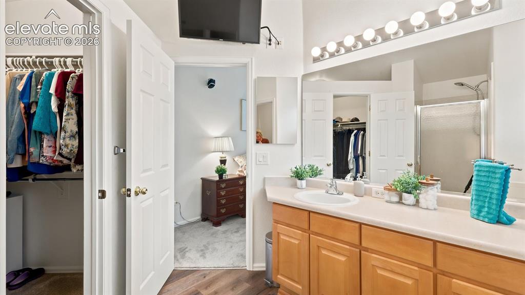 Image 35 of 46: The Primary Bathroom features a vanity, mirror, soaking tub, and separate s