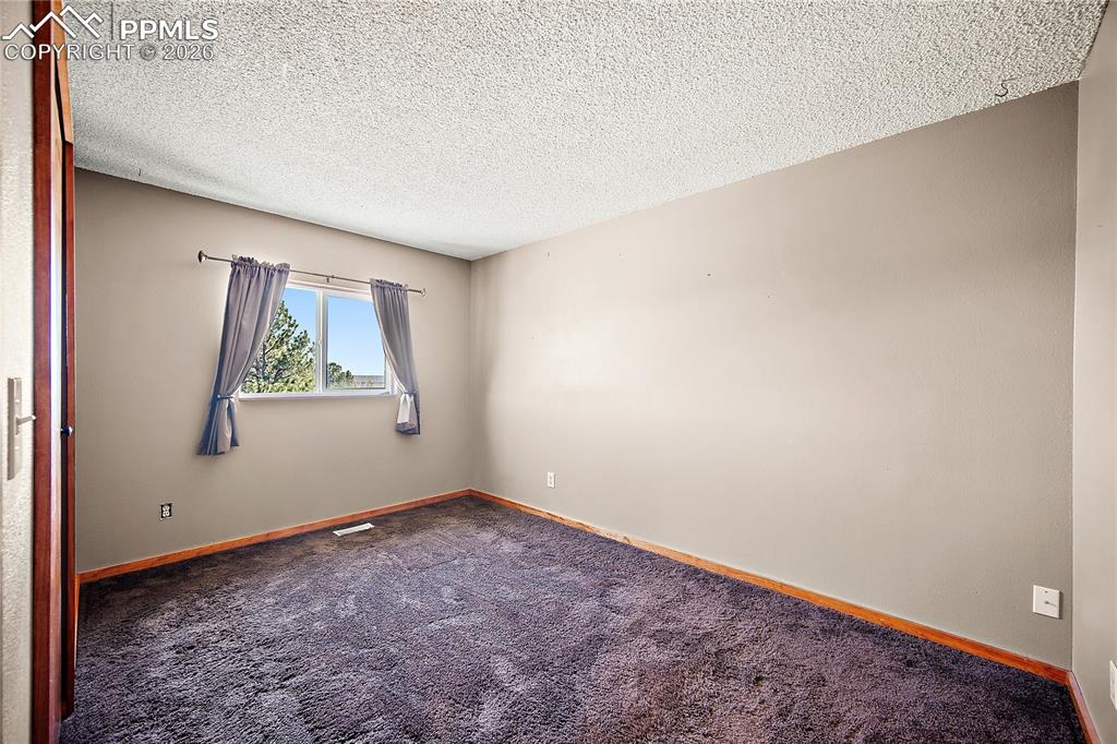 Image 16 of 40: Bedroom with carpet, large window and good sized closet.