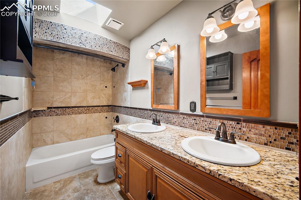 Image 18 of 40: Upstairs updated full bath with double vanity.