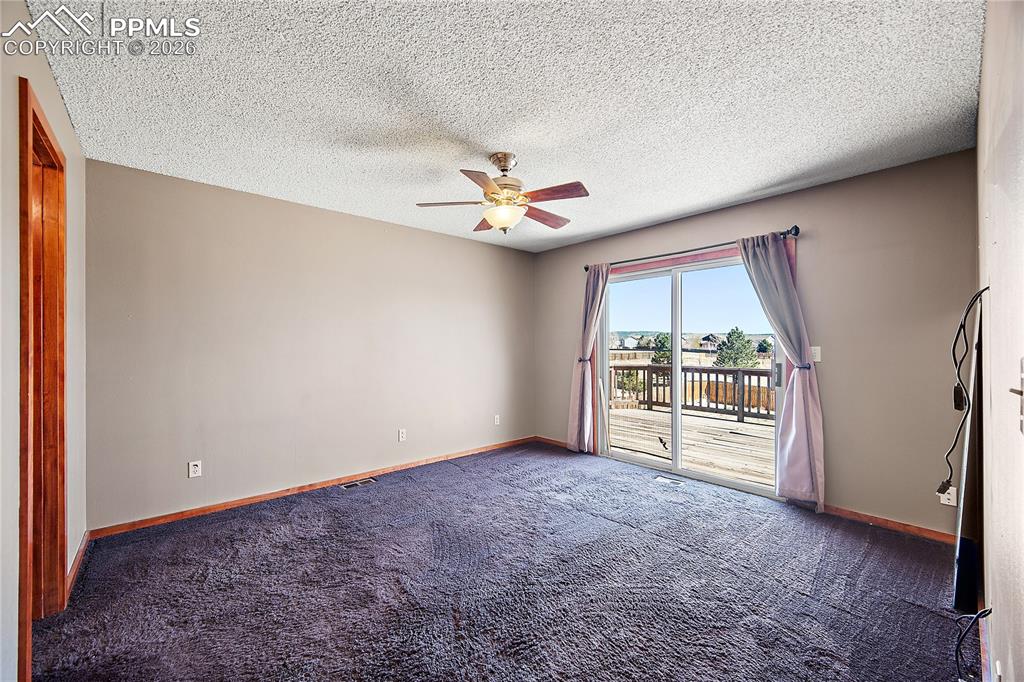 Image 21 of 40: Primary bedroom with carpet, walk out to spacious deck and mountain views.