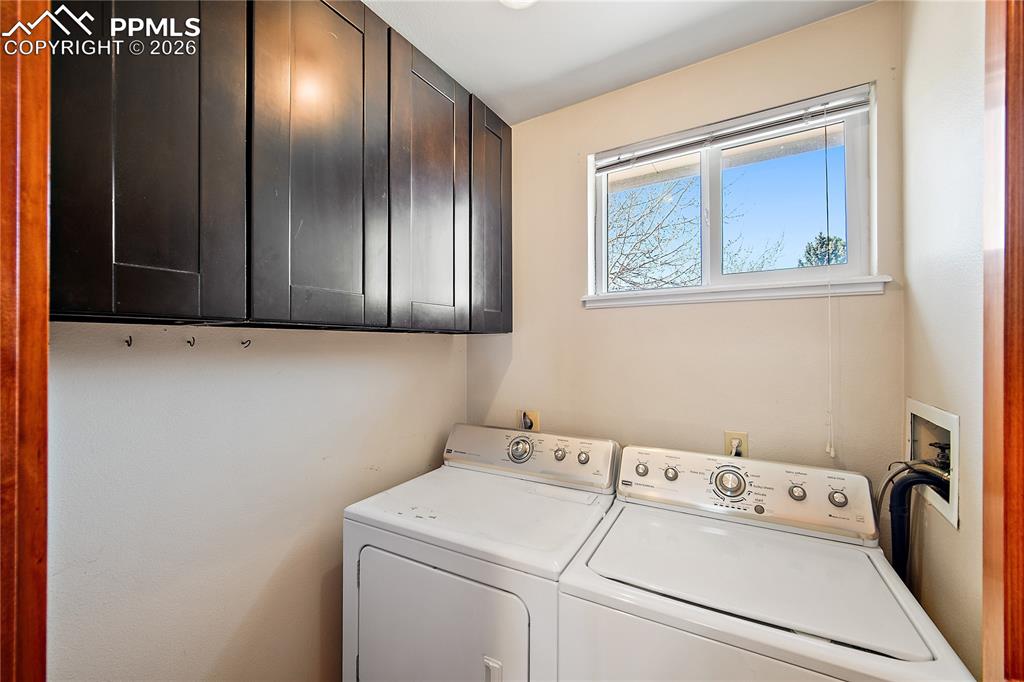 Image 28 of 40: Upstairs laundry with window and storage.