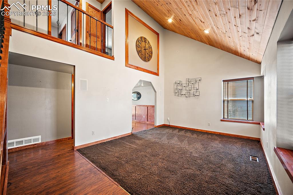 Image 4 of 40: Living room with vaulted and tongue and grove ceiling