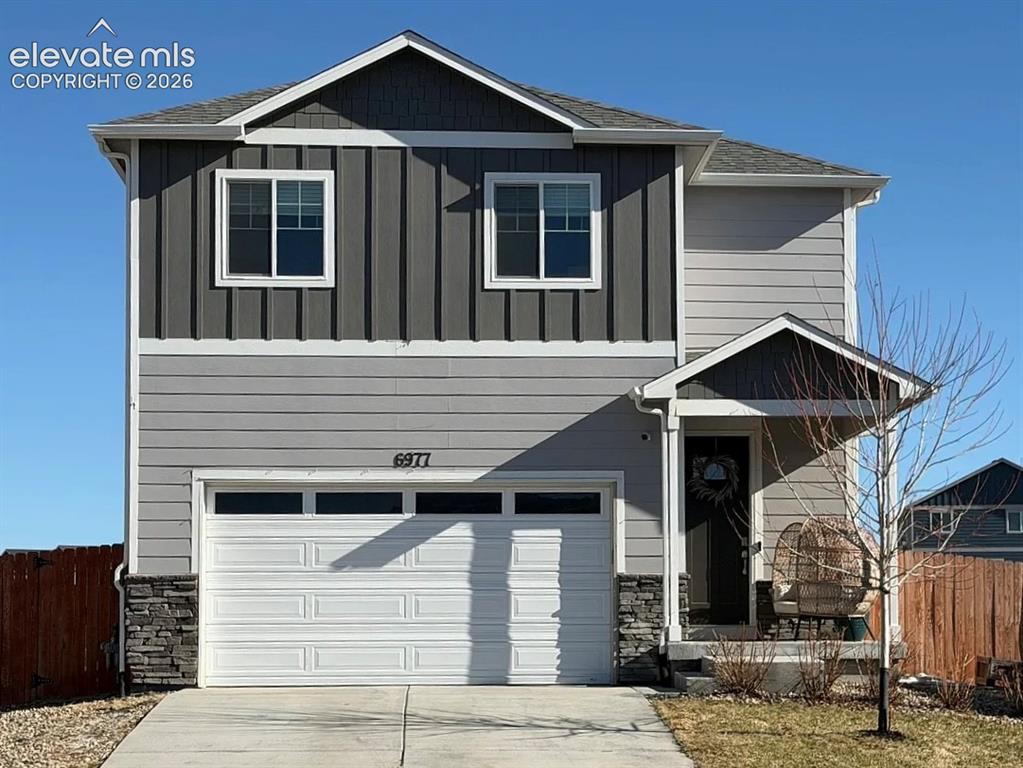Caption: Contemporary two-story residence featuring a gray and dark gray facade with board and batten siding 