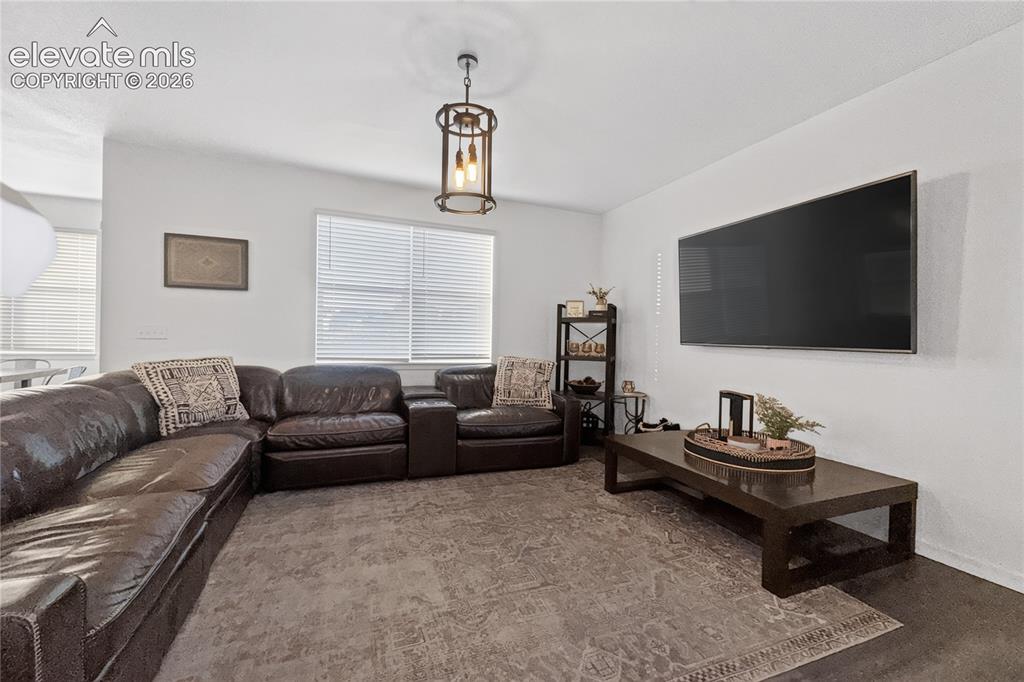 Image 13 of 22: Spacious living area featuring dark wood-finish flooring, a contemporary ce