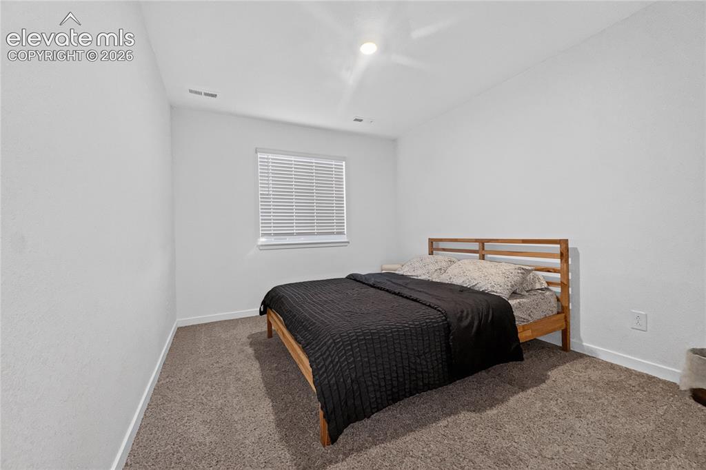 Image 14 of 22: Carpeted room with a window featuring horizontal blinds