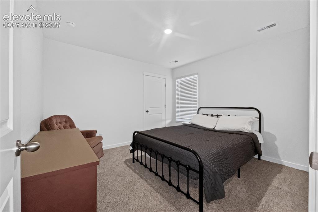 Image 17 of 22: Carpeted room with a recessed light fixture, white walls, and a window feat