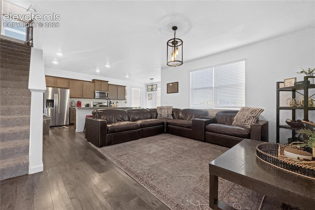 Image 2 of 22: Open-concept living space featuring wood-finish flooring and a contemporary