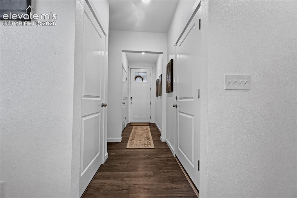 Image 21 of 22: Entryway corridor featuring wood-finish flooring, white walls, and bright o
