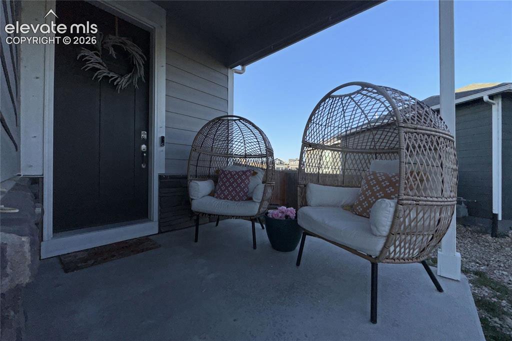 Image 22 of 22: Covered front porch with concrete flooring and horizontal siding