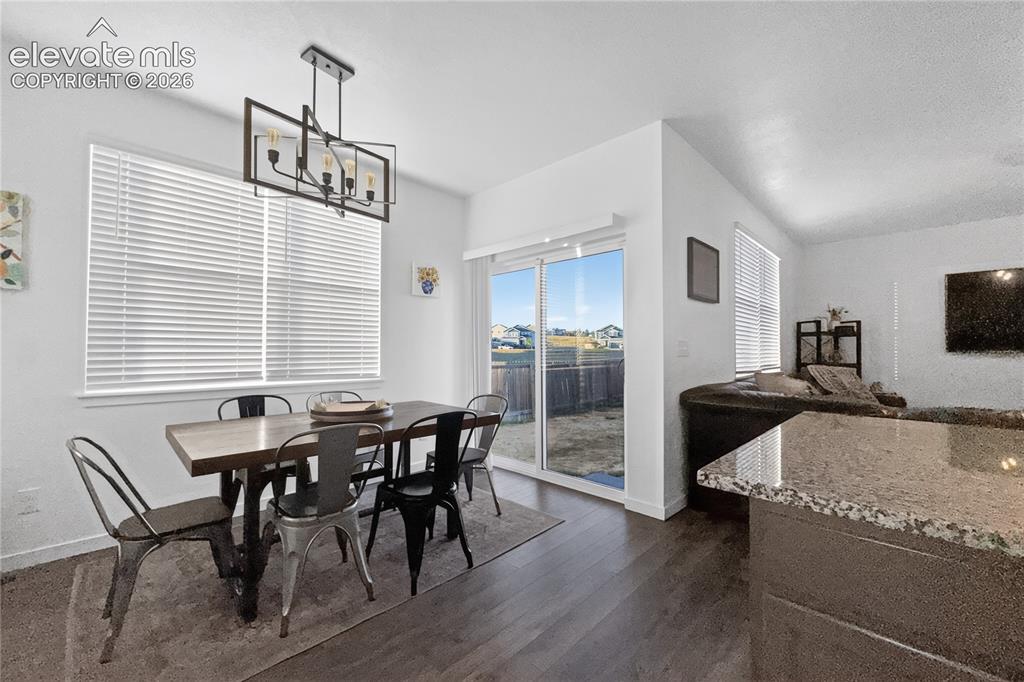 Image 5 of 22: Dining area featuring wood-finish flooring and a contemporary linear chande
