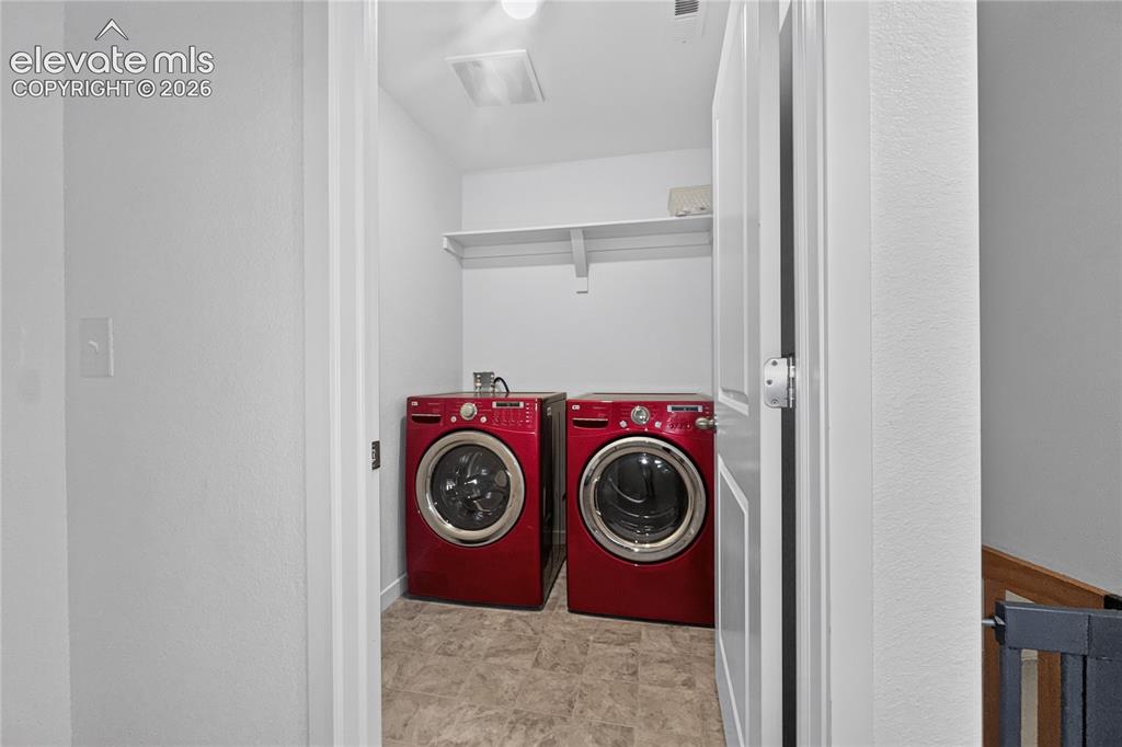 Image 7 of 22: Dedicated laundry area with durable flooring and built-in shelving