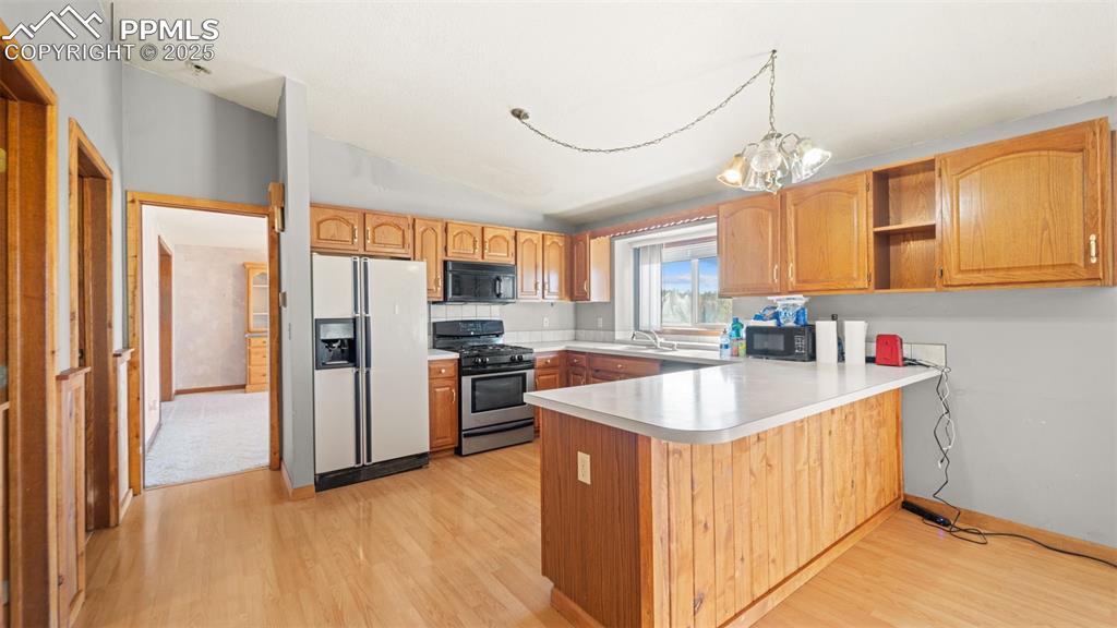 Image 10 of 36: Kitchen with vaulted ceiling, white refrigerator with ice dispenser, stainl