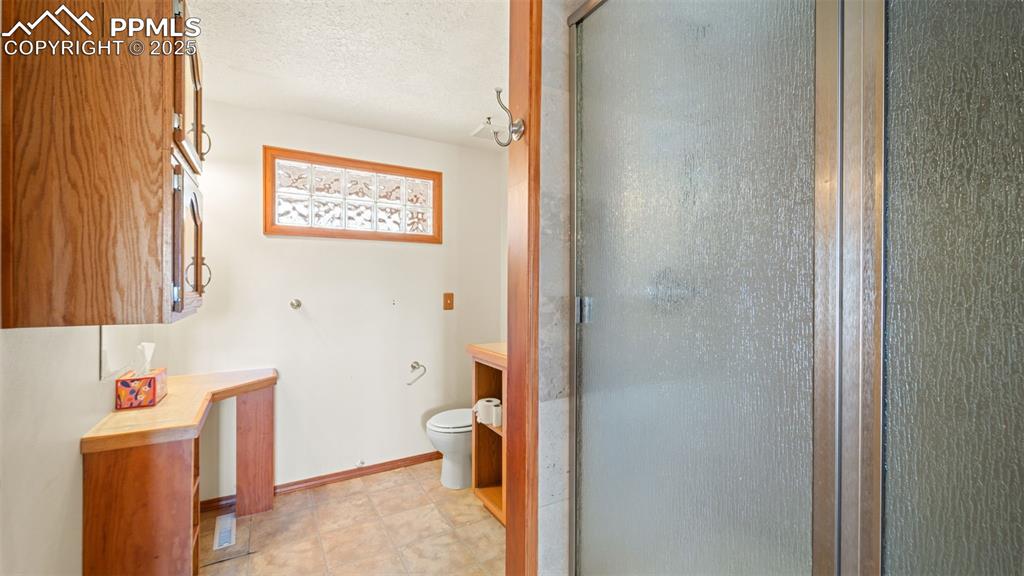 Image 13 of 36: Full bath featuring a shower stall, a textured ceiling, and vanity