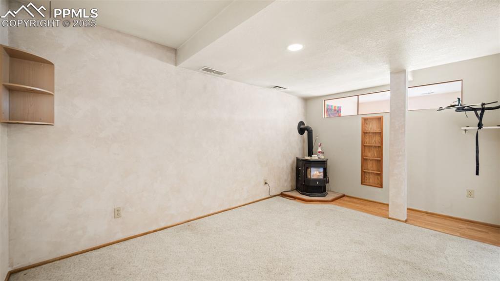 Image 20 of 36: basement with pellet stove.