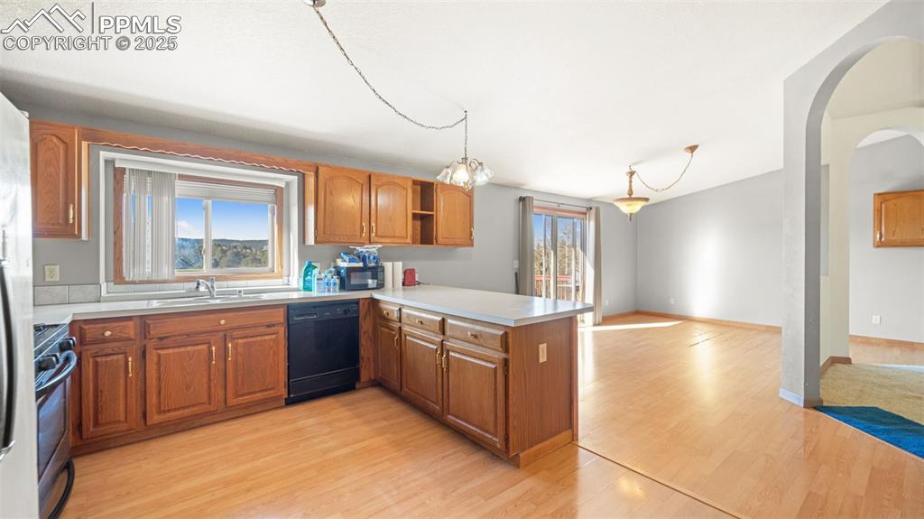 Image 7 of 36: Kitchen with light wood-type flooring, light countertops, vaulted ceiling, 