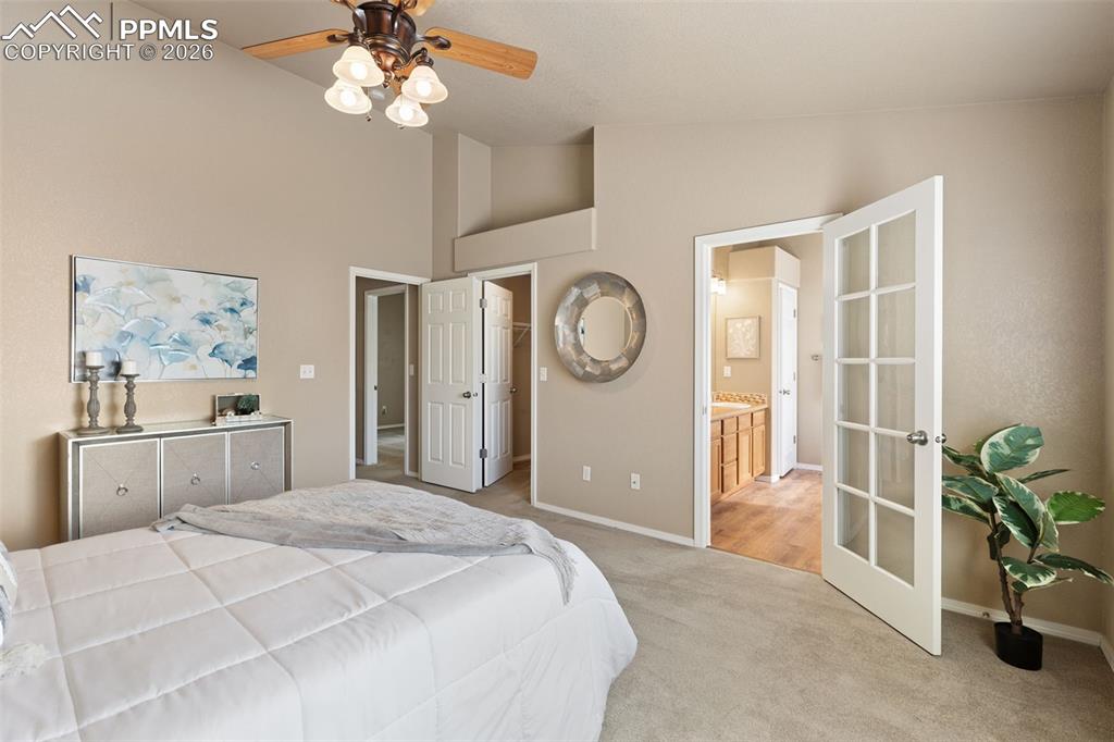 Image 18 of 44: Primary bedroom with view into adjoining 5 piece bath.