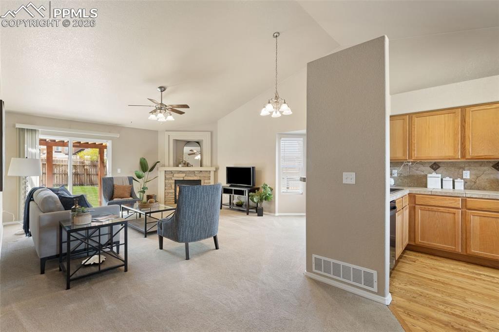 Image 7 of 44: Living room with walkout, fireplace and ceiling fan.