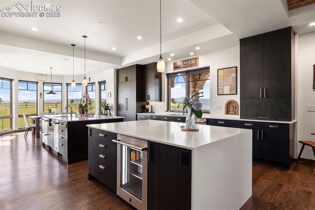 Image 13 of 36: Double waterfall quartz islands, floor-to-ceiling cabinetry, and JennAir ap