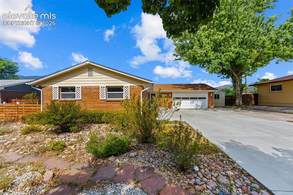 Caption: Ranch-style residence featuring brick and siding exterior, a two-car garage with white door, and a c
